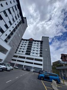 a large building with a car parked in a parking lot at Cloud Nine Homestay in Tanah Rata