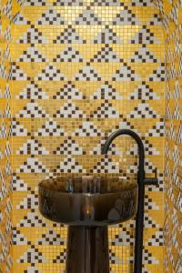 a sink in a bathroom with a tiled wall at Torre Saracena Massa Lubrense in Massa Lubrense