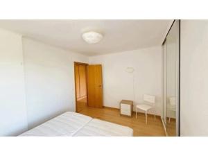 a white bedroom with a bed and a mirror at Apartamento Summer Place in Monte Gordo