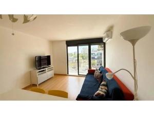 a living room with a blue couch and a lamp at Apartamento Summer Place in Monte Gordo