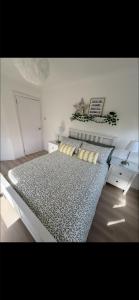 a bedroom with a large bed with pillows on it at Dove Cottage in Greenock