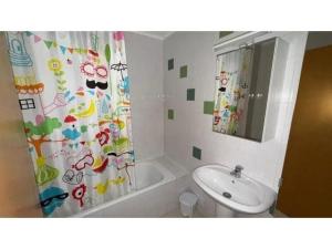 a bathroom with a shower curtain and a sink at Apartamento Summer Place in Monte Gordo +19 photos