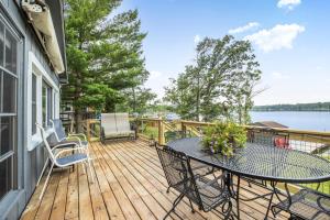 a wooden deck with a table and chairs on it at The Cozy Cub in Cross Lake