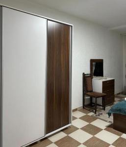 a bedroom with a sliding door with a chair and a desk at Down Town Apartment 2 in Gnjilane +19 photos