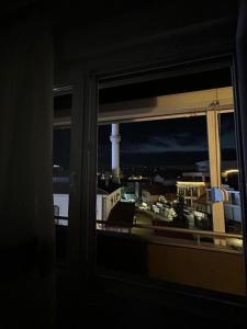 a window with a view of a city at night at Down Town Apartment 2 in Gnjilane