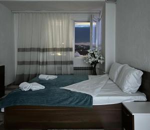 a bedroom with a large bed with two towels on it at Down Town Apartment 2 in Gnjilane
