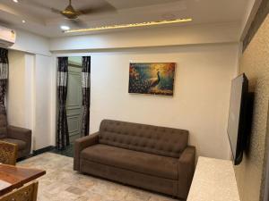 a living room with a couch and a painting on the wall at Divine Abode in Thane