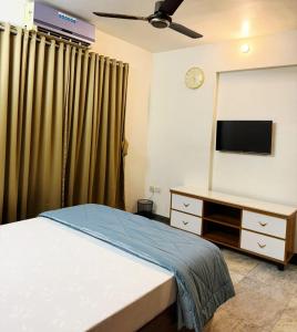 a bedroom with a bed and a flat screen tv at Divine Abode in Thane