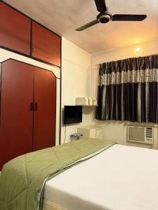 a bedroom with a bed with a ceiling fan at Divine Abode in Thane