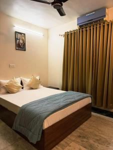 a bedroom with a large bed with green curtains at Divine Abode in Thane +2 photos