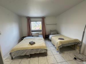 two beds in a room with a window at Zimmer für 2 Monteure in Heppenheim Kirschhausen in Kirschhausen