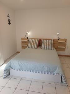 a bedroom with a large bed with two pillows at Maison le Flamant in Port-Saint-Louis-du-Rhône