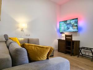 ein Wohnzimmer mit Sofa und Flachbildfernseher in der Unterkunft Csórtok in Lug