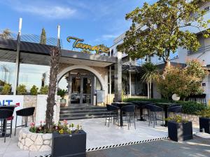 a restaurant with tables and chairs in front of a building at Tamaris Rooms in Zadar