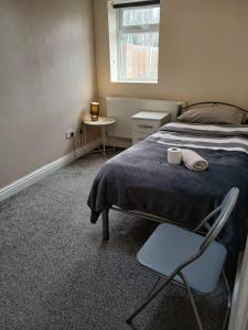 a bedroom with a bed and a chair and a window at Devonshire House in Birmingham