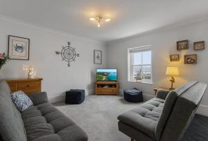 a living room with a couch and a tv at Quayside Marina in Torquay