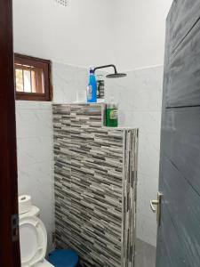 a small bathroom with a toilet and a window at Carinho da Paz in Inhambane +9 photos