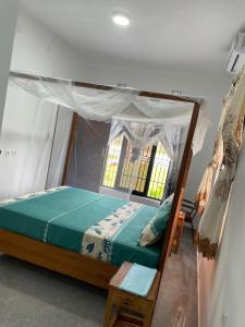 a bedroom with a canopy bed and a window at Carinho da Paz in Inhambane