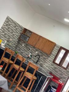 a kitchen with three chairs and a brick wall at Carinho da Paz in Inhambane