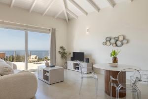 a living room with a table and a view of the ocean at Magganos Sunset Villas in Fiskardo
