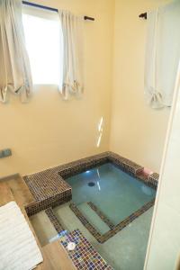 a pool of water in a bathroom with a window at Almond Tree Villa Beach Hideaway with Jacuzzi in Gros Islet