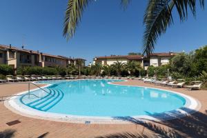 a large swimming pool with chairs and a resort at Charme Relax e Terrazza a Vista in Sirmione