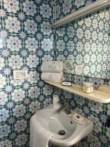 a bathroom with blue and white tiled walls and a sink at Hôtel Bou Fares in Sidi Bou Saïd +30 photos