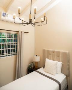 a bedroom with a bed and a chandelier at Almond Tree Villa Beach Hideaway with Jacuzzi in Gros Islet +65 photos