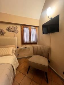 a bedroom with a bed and a chair and a television at Casa le valli in Cantagrillo