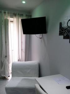 um quarto com 2 camas e uma televisão de ecrã plano em B&b La Ferrovia em Benevento