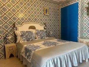 a bedroom with a bed with blue doors and wallpaper at Hôtel Bou Fares in Sidi Bou Saïd