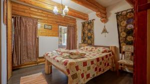 a bedroom with a bed in a log cabin at Dolce Cabana in Timisul de Jos