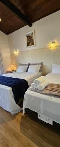 a bedroom with two beds and two lamps at Quarto Familiar Centro in Pomerode
