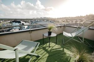a balcony with two chairs and a table at Le Nautica Hôtel in Perros-Guirec