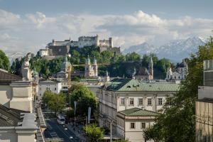 a view of a city with a castle on a hill at IMLAUER HOTEL PITTER Salzburg in Salzburg