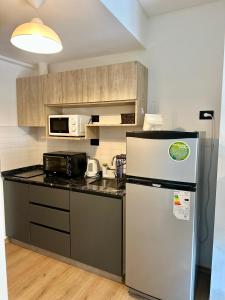 a kitchen with a refrigerator and a microwave at Terrazas de Godoy in Godoy Cruz