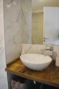 a bathroom with a white sink and a mirror at Terrazas de Godoy in Godoy Cruz +9 photos