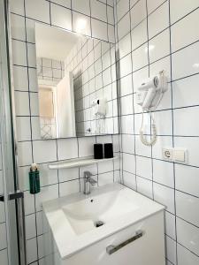 a white bathroom with a sink and a mirror at Apartments Antic 1 in Pješčana Uvala +66 photos