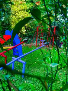 a red and blue playground in the grass at Villa Aggeliki in Prinos