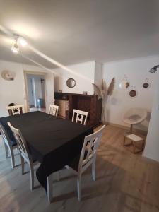 a dining room with a black table and chairs at Le Domaine Des Petits Chat in Orchamps +5 photos