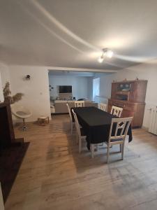 a living room with a black table and chairs at Le Domaine Des Petits Chat in Orchamps
