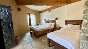 a bedroom with two beds in a room at Bhanjyang Village Lodge in Pokhara