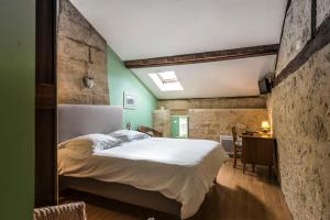 a bedroom with a large bed in a room with green walls at Château Croix Beauséjour "Maison du Vigneron" in Montagne