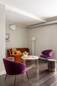a living room with purple chairs and a table at Barberini Retreat Boutique Hotel in Rome