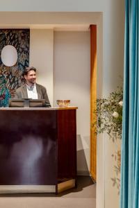 a man sitting at a desk with at Barberini Retreat Boutique Hotel in Rome