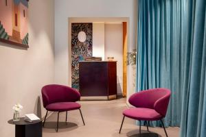 a waiting room with two pink chairs and a podium at Barberini Retreat Boutique Hotel in Rome