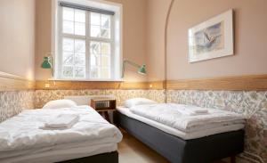 two beds in a room with a window at Anneberg Gæstehus in Nykøbing Sjælland