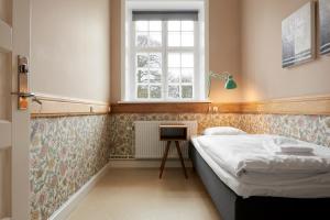 a small bedroom with a bed and a window at Anneberg Gæstehus in Nykøbing Sjælland +18 photos