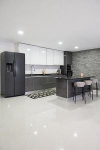 a kitchen with a stainless steel refrigerator and stools at Salt & Sand T3 in Praia +15 photos
