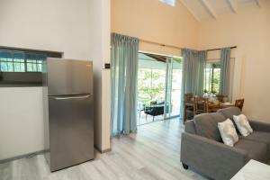 a kitchen and living room with a couch and a refrigerator at Almond Tree Villa Beach Hideaway with Jacuzzi in Gros Islet